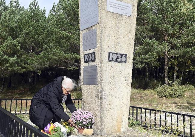 Una mujer deposita flores en el monumento en homenaje a las víctimas de la dictura en La Pedraja.