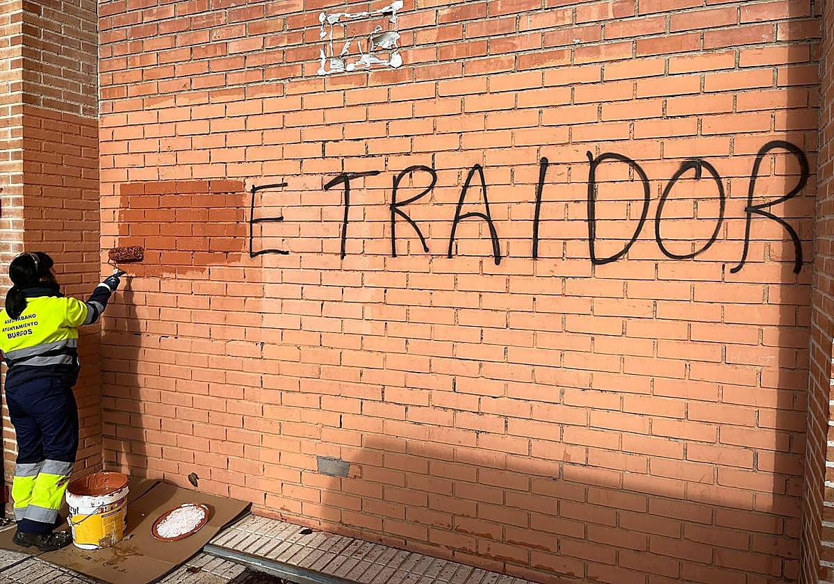 Un operario procede a la limpieza de una pintada contra el PSOE