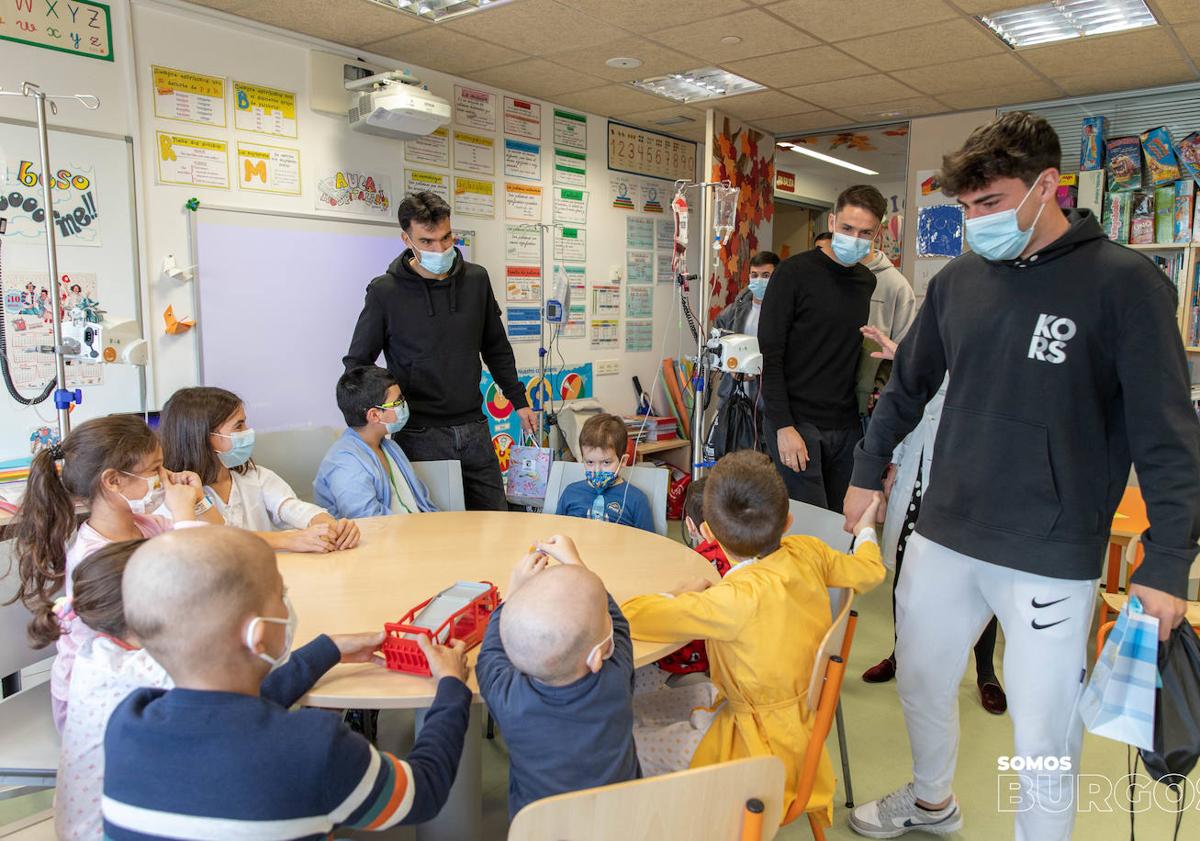 Imagen principal - El Burgos CF llena de ilusión y regalos la planta infantil del HUBU por Navidad