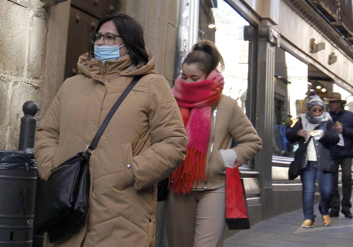 Una mujer con mascarilla por la calle.