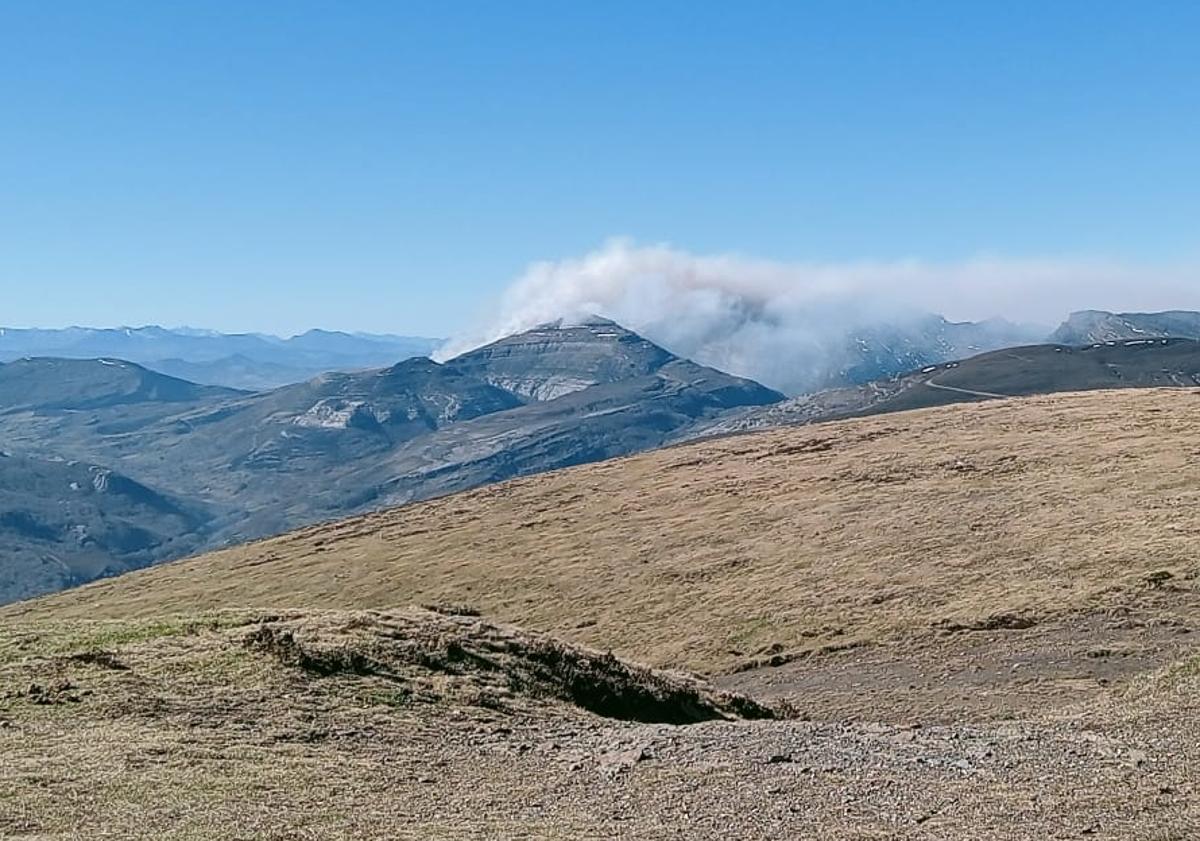 Imagen principal - Aunque pueden parecer nubes, se trata del humo que sigue desprendiendo el incendio y que se aprecia desde el Picón Blanco. 