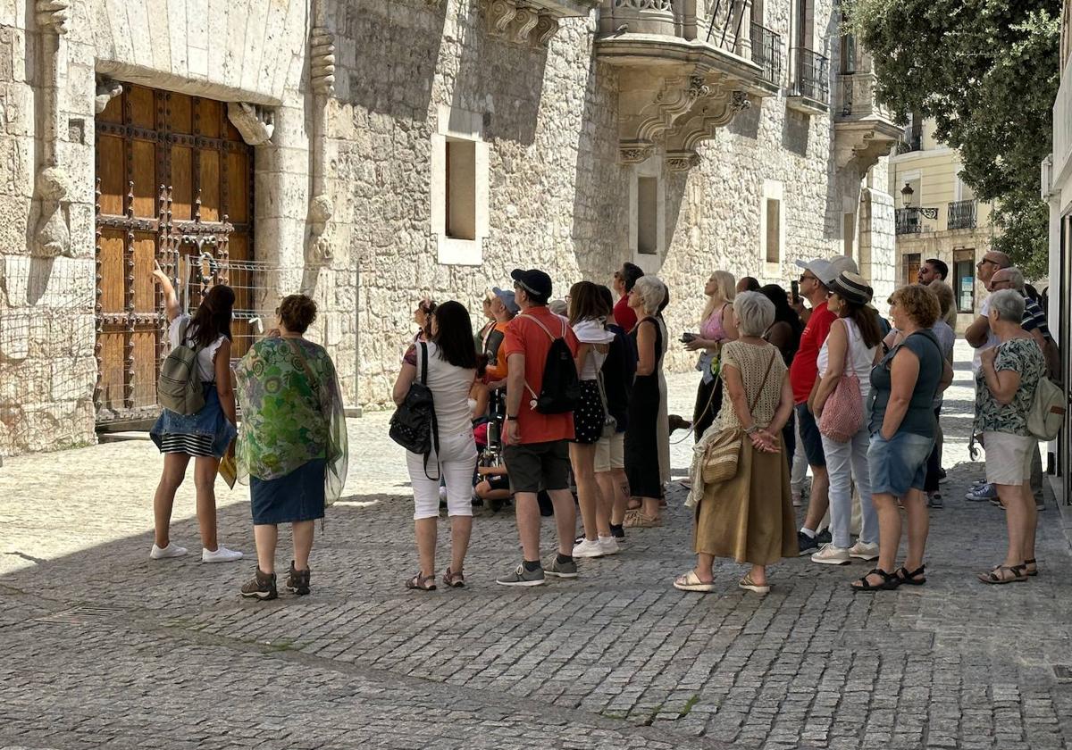 Una guía explica el Palacio de los Condestables de Castilla -o Casa del Cordón- a un grupo de turistas este verano en Burgos