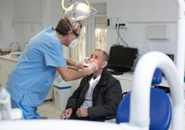Un odontólogo de la Clínica Odontología Solidaria atiende a un paciente.