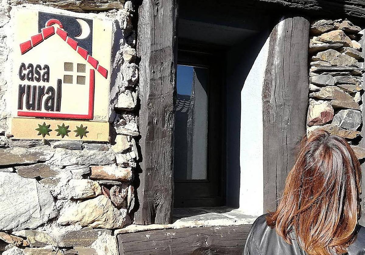 Imagen de archivo de una turista frente a una casa rural