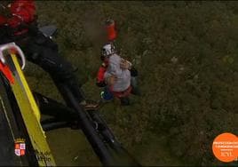 El senderista herido es izado al helicóptero de rescate.