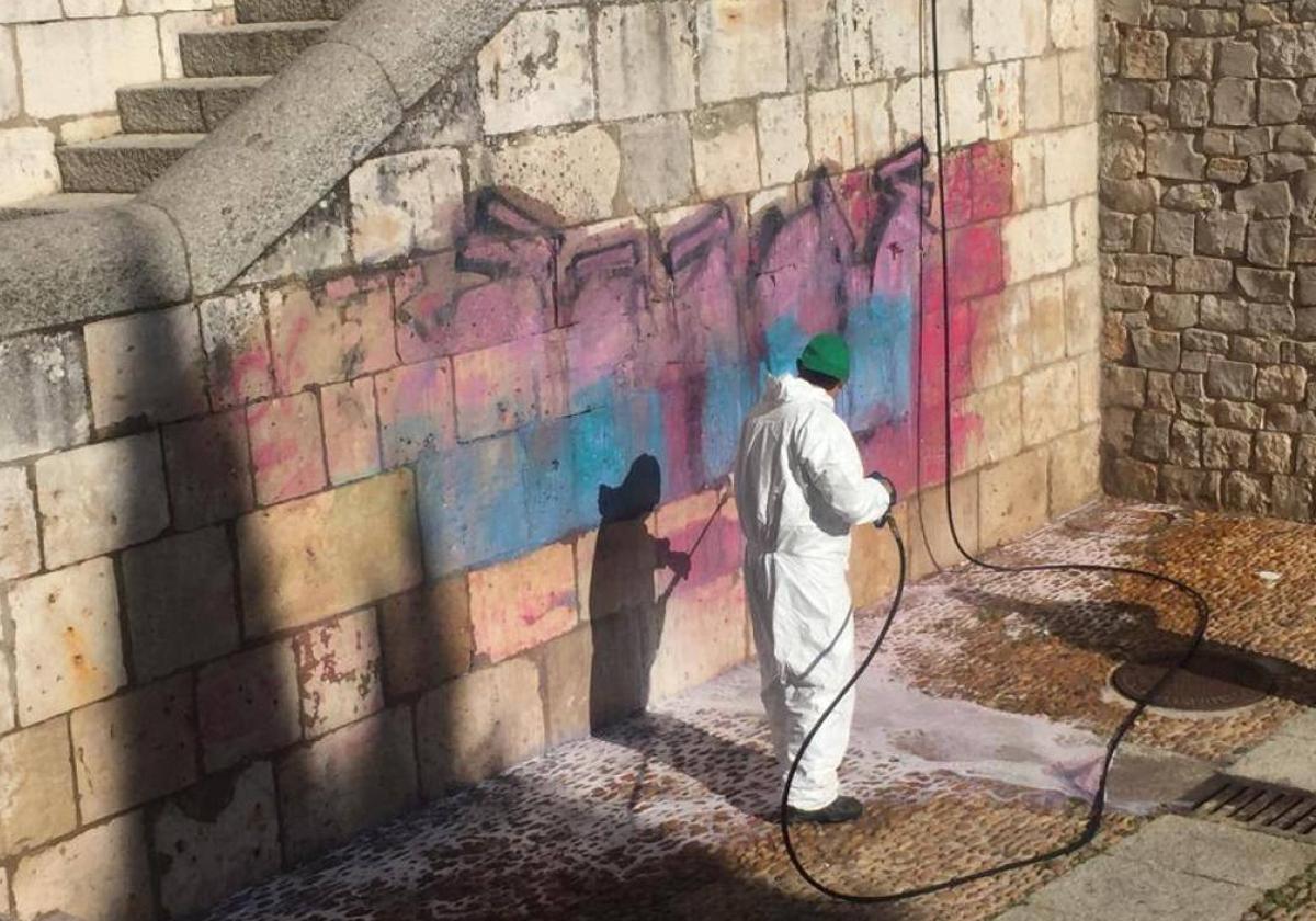 Personal del Ayuntamiento de Burgos retira un grafiti en Burgos.