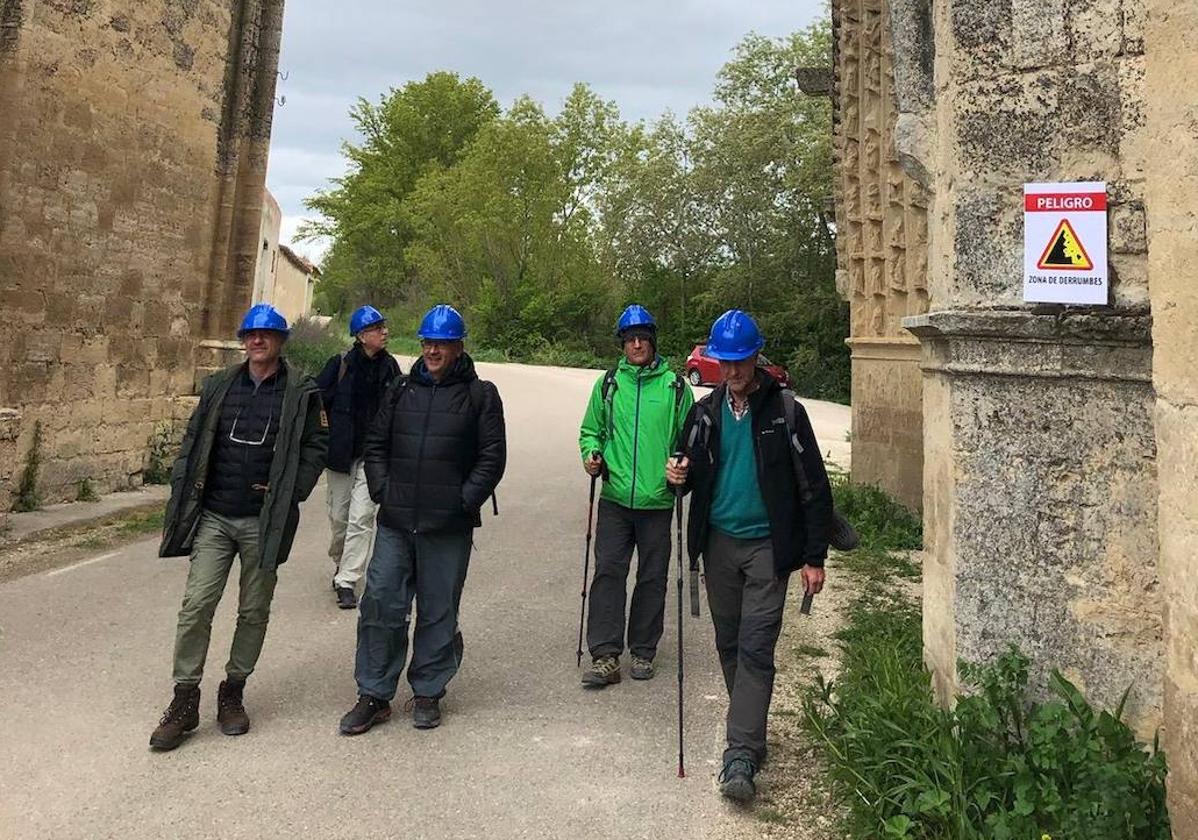 Peregrinos con casco pasando por las ruinas del convento de San Antón, en Castrojeriz.