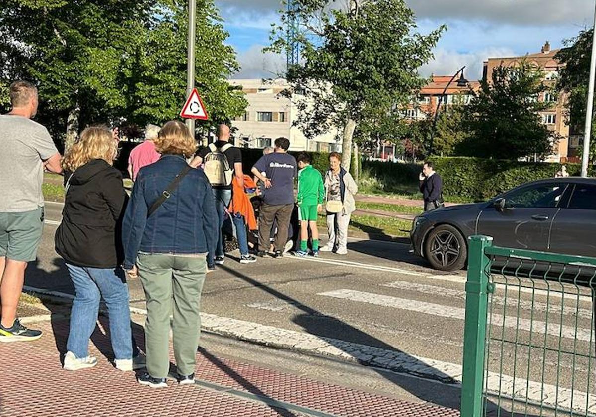 Un grupo de gente se preocupa por la herida en el atropello ocurrido en el paso de peatones de la calle Cartuja de Miraflores.