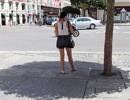 Una mujer, resguardándose a la sombra en un día de calor en Burgos.