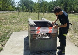 Imagen de archivo de un bombero precintando una barbacoa.