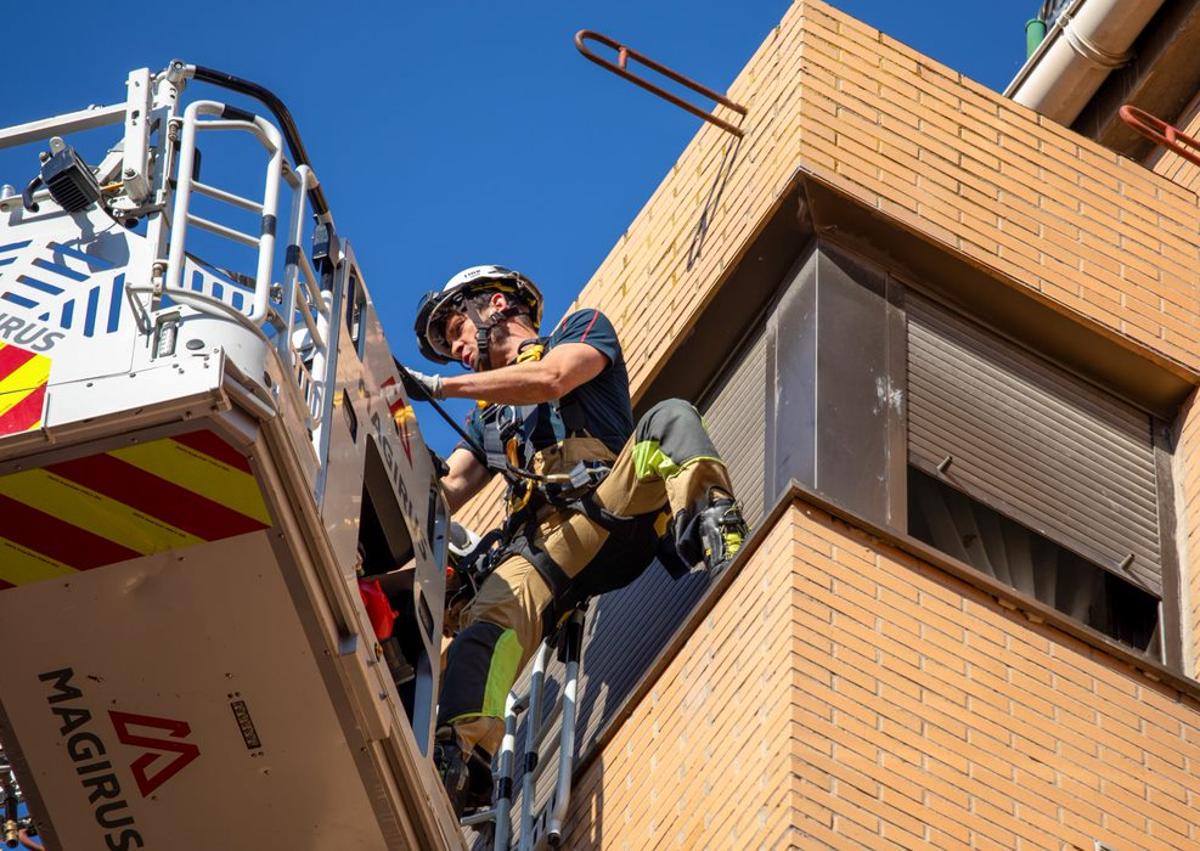 Imagen secundaria 1 - Los Bomberos de Burgos trabajan para acceder a una casa por la ventana.