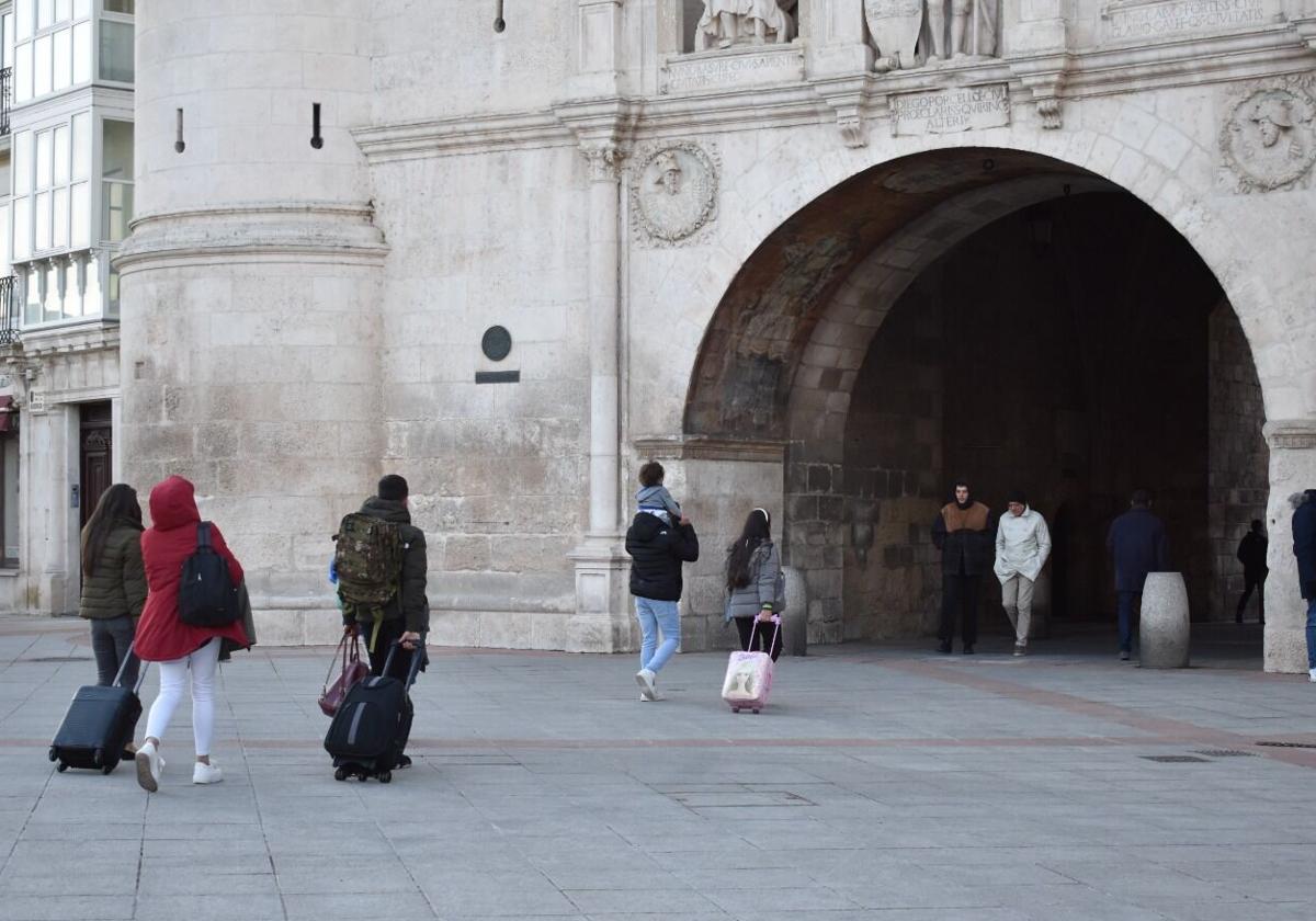 Turistas con sus equipajes en el arco Santa María de Burgos.