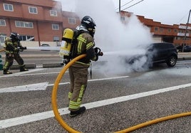 Los Bomberos de Burgos sofocan las llamas en el vehículo incendiado en plena carretera.