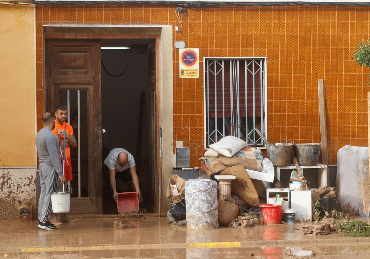 Vecinos de La Alcudia limpiando sus casas y objetos tras la DANA.