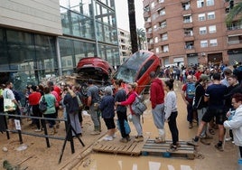 Varias personas esperan para recibir ayuda este jueves en Paiporta (Valencia).