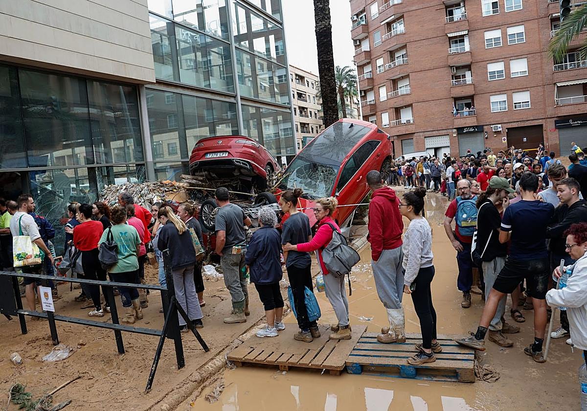 Varias personas esperan para recibir ayuda este jueves en Paiporta (Valencia).