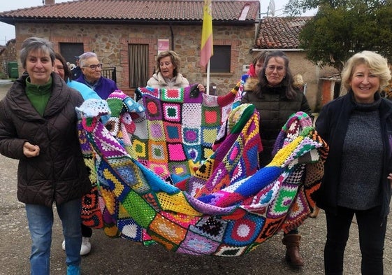 Las mujeres del pueblo transportan los metros de tela de ganchillo que han tejido para componer el árbol de Navidad.