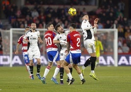 La defensa del Granada se emplea a fondo para despejar un balón.