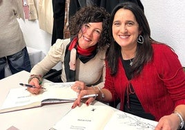 Escribano y Domaica firmando libros.