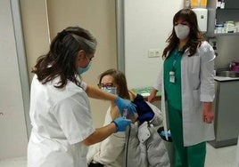 Personal de enfermería administran una vacuna en un centro de salud.
