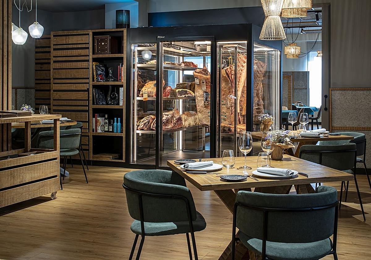 Sala del restaurante, con la cava de carnes al fondo.