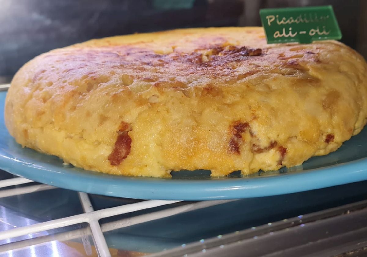 Imagen principal - Arriba, tortilla de picadillo; en el medio, de jamón serrano y alioli y una tortilla preparada para llevarla.