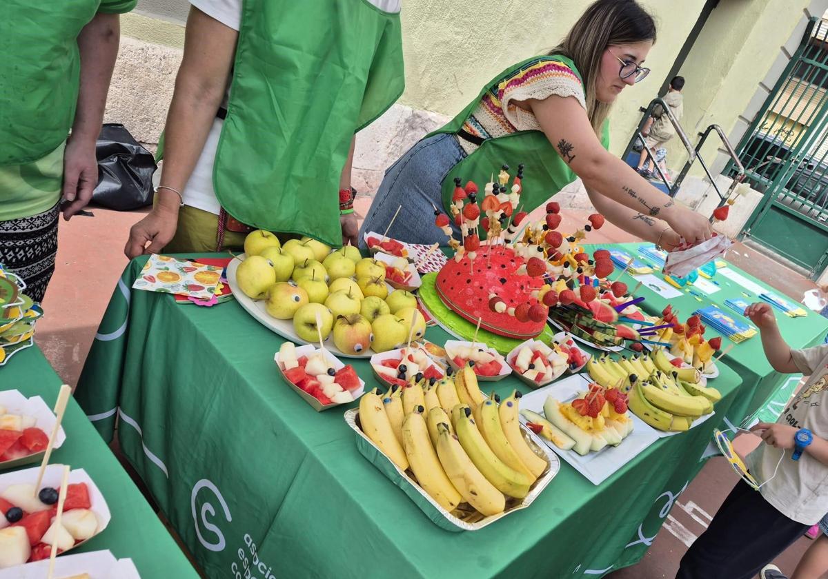 Voluntarios reparten la fruta entre los alumnos.