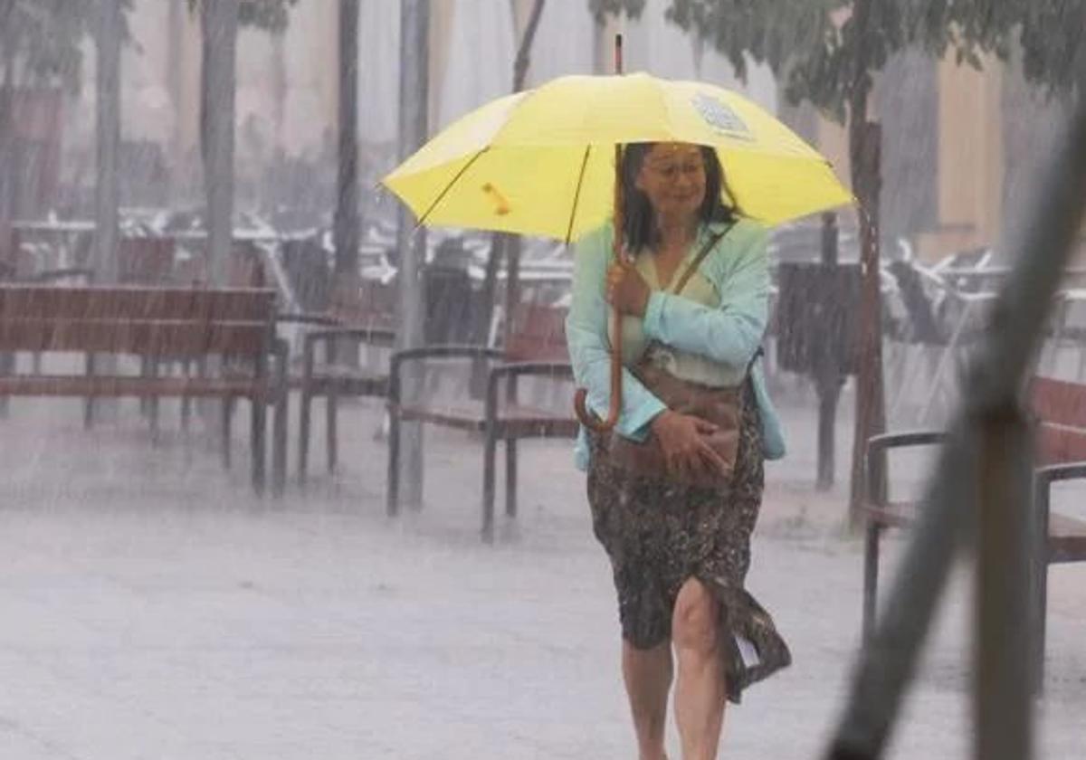Una mujer en medio de una tromba de agua.