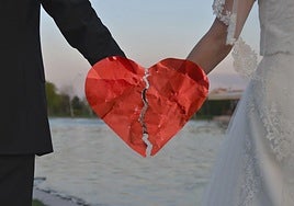 Imagen de una pareja recien casada en la que se puede ver en medio de la imagen un corazón roto