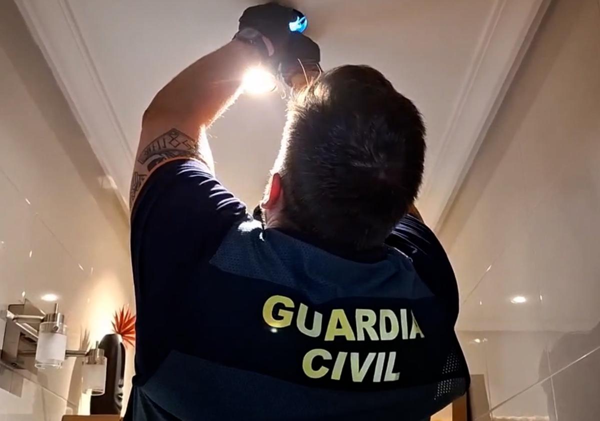 Imagen principal - Momento en el que la Guardia Civil descubre las cámaras ocultas en el baño. 