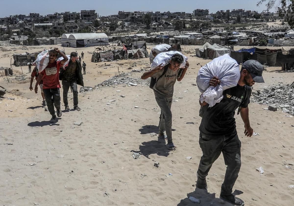 Un grupo de gazatíez recoge ayuda humanitaria.