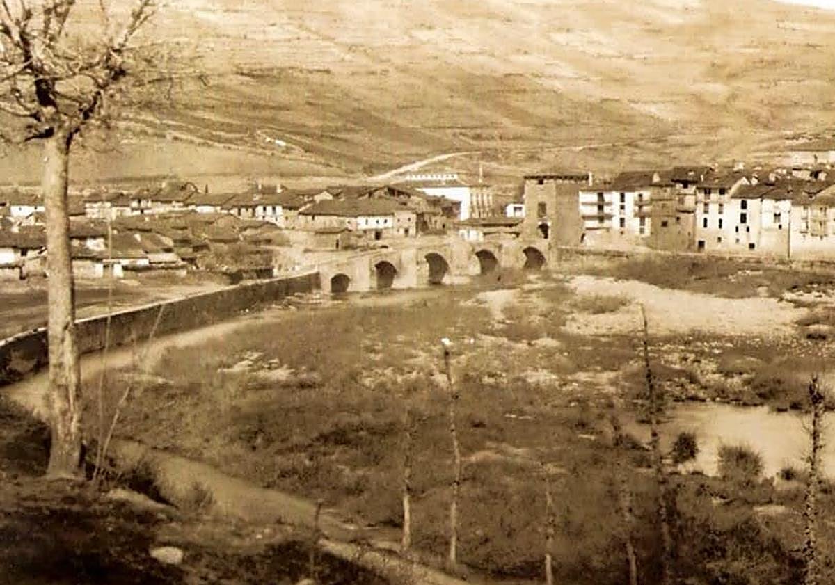 Imagen principal - Fotografía antigua de Covarrubias con el puente original medieval y recreación del actual de cartón. 