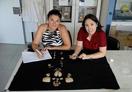 La profesora Rebeca García González (izquierda) y Marta Fernández Viejo, investigadora predocotral-Junta Castilla y León (programa en Evolución Humana de la UBU) con los restos del estudio.