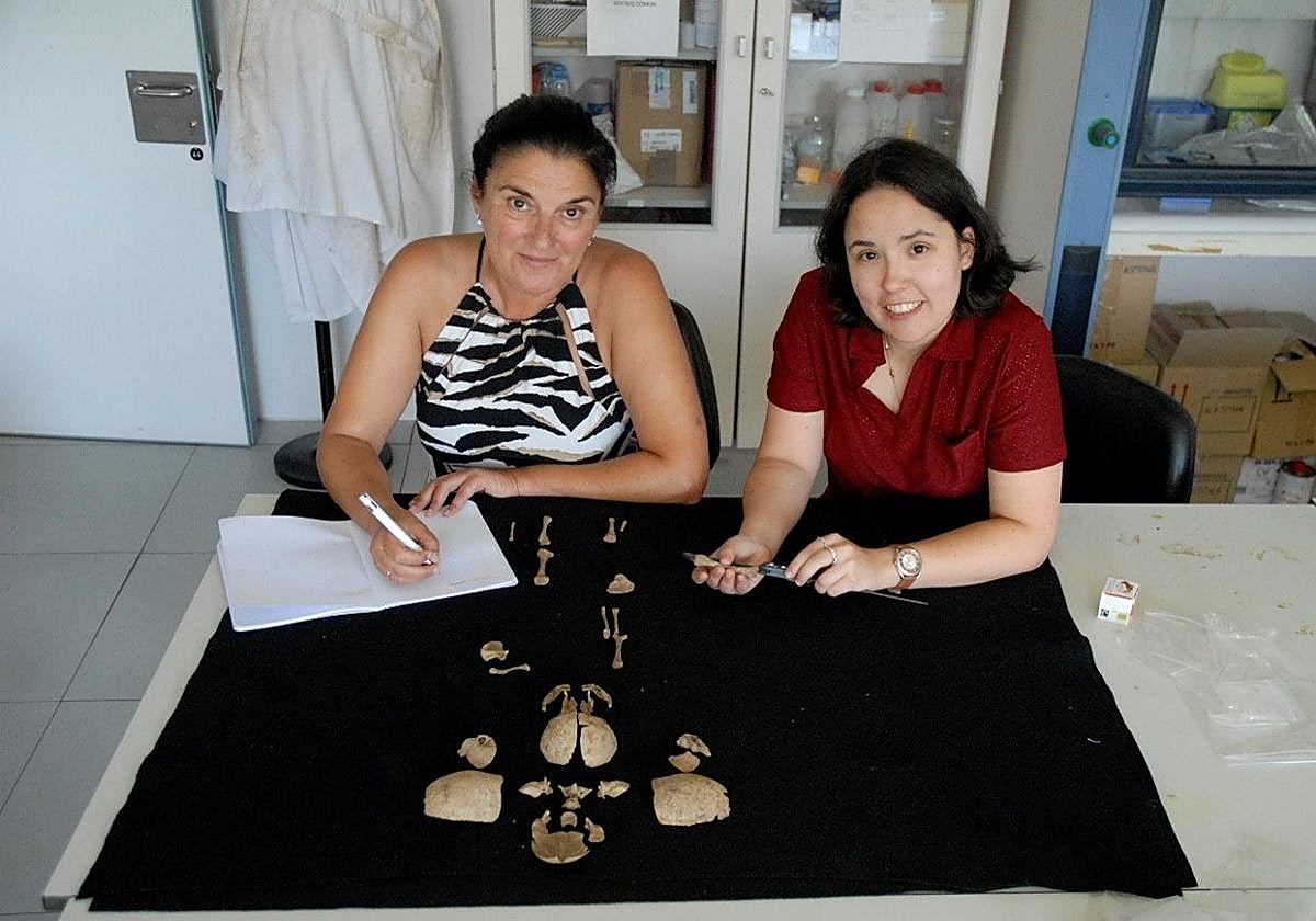 La profesora Rebeca García González (izquierda) y Marta Fernández Viejo, investigadora predocotral-Junta Castilla y León (programa en Evolución Humana de la UBU) con los restos del estudio.