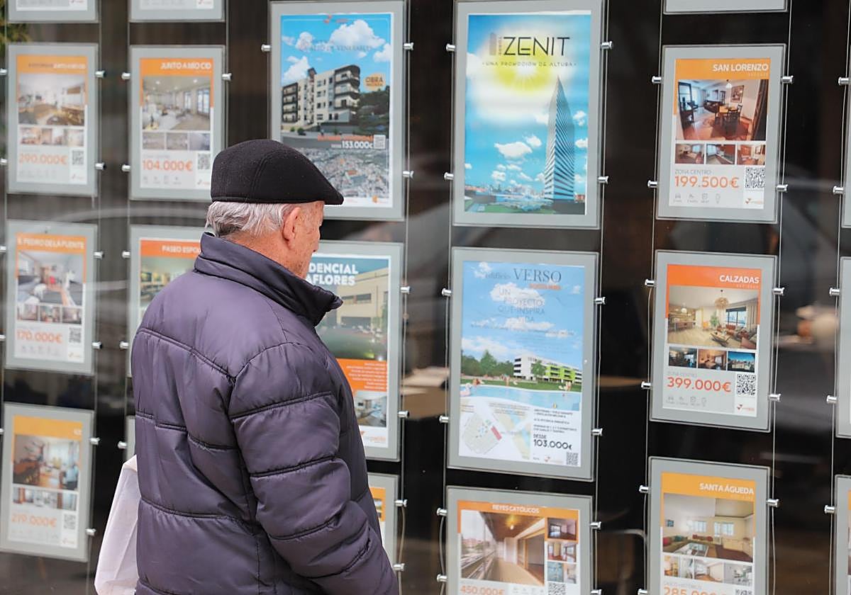 Un hombre observa los anuncios de viviendas en una inmobiliaria.