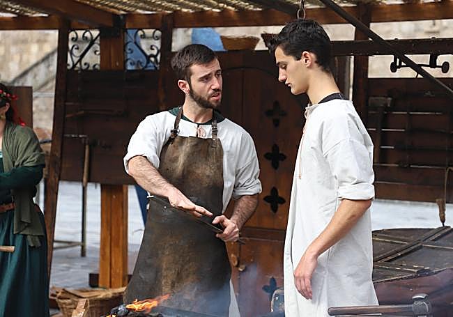 Dos herreros se preparan para la forja.