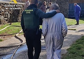 El hombre cuya vivienda se incendió siendo atendido por un agente de la Guardia Civil.