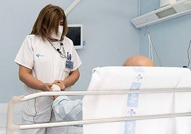 La enfermera Consuelo García atiende a un enfermo oncológico en el Hospital Clínico de Valladolid.