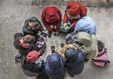 Un grupo de escolares navega por internet con sus teléfonos móviles.
