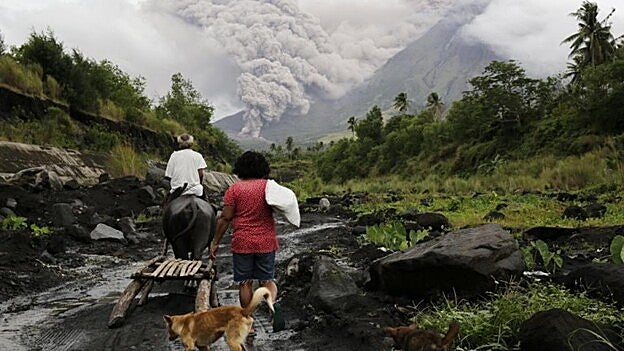 Habitantes filipinos transitan cerca del volcán /  Efe