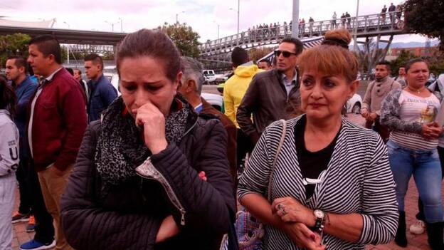 Varias personas esperan información sobre sus familiares en el lugar donde un carro bomba causó una explosión este jueves en la Escuela General Santander de la Policía. / Efe.