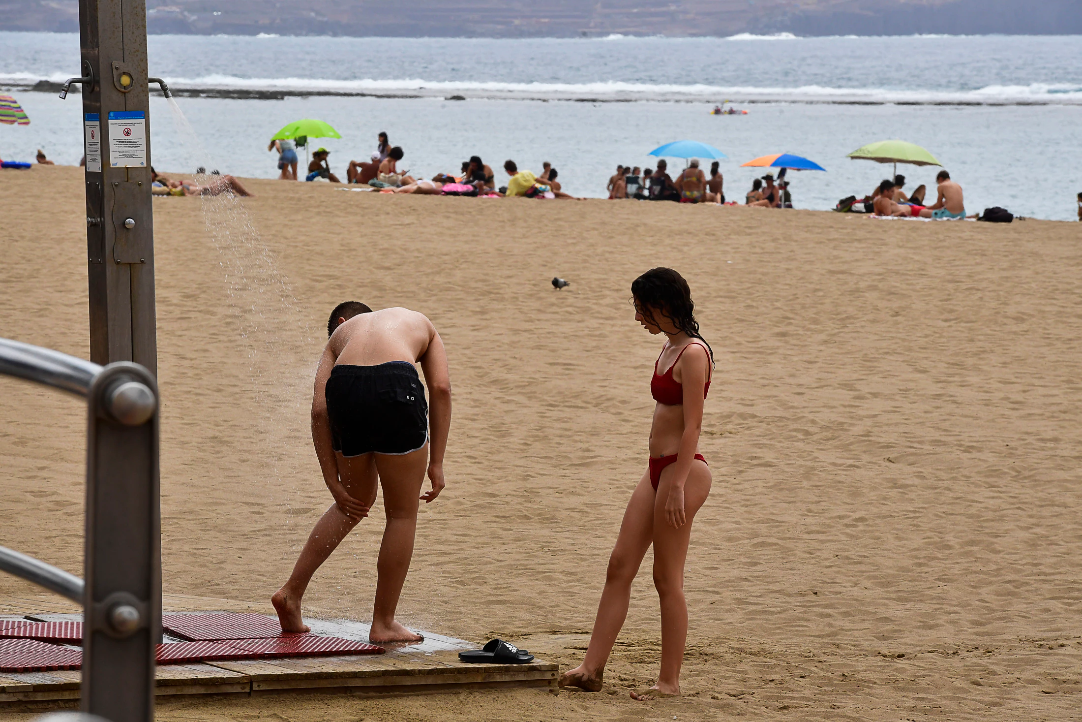 Dos jóvenes se refrescan en la citada playa