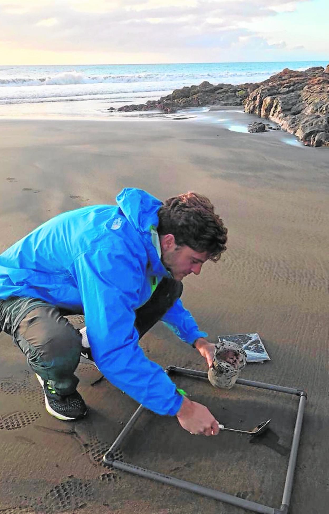 Un investigador recoge microplásticos en una playa canaria. 