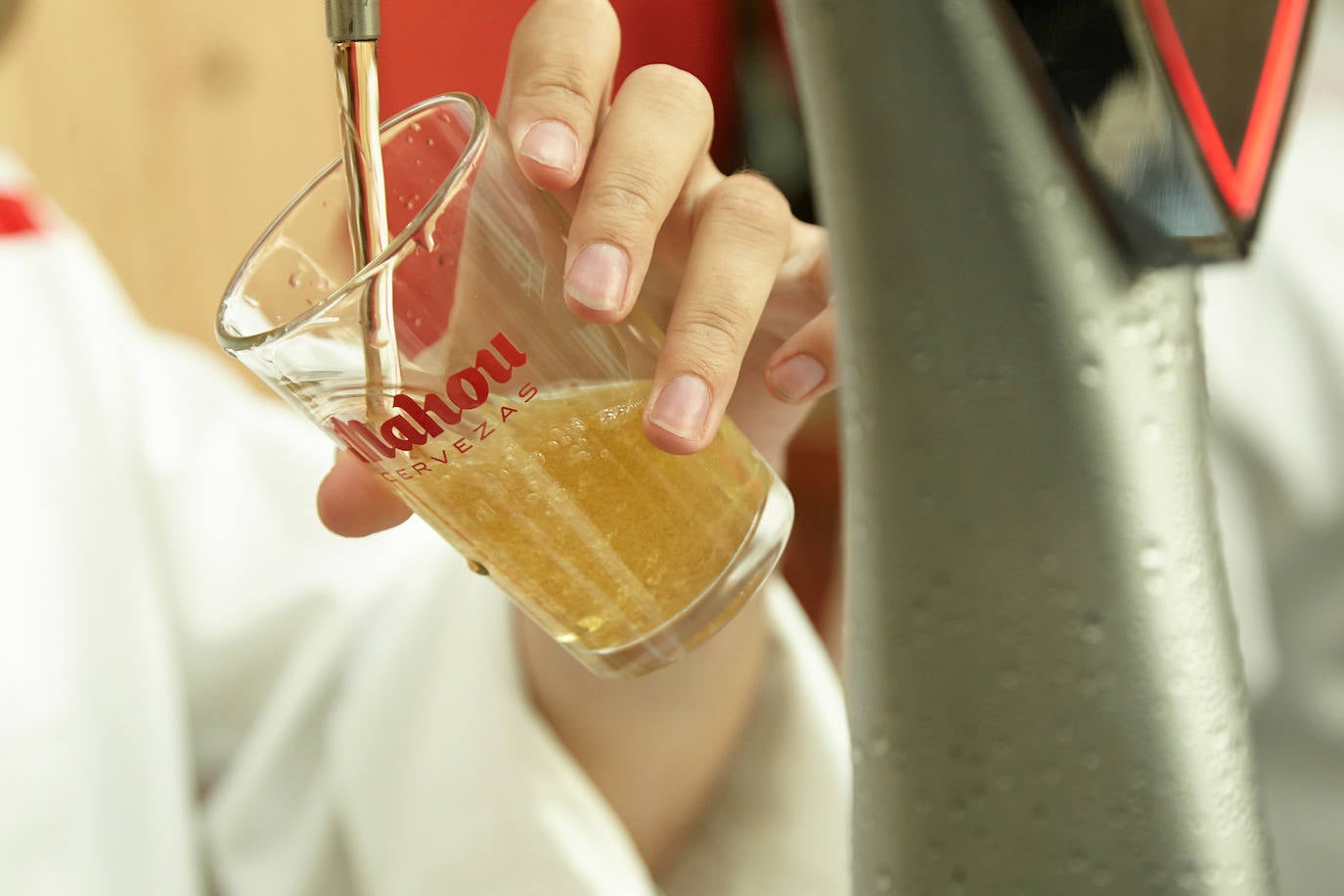 Imagen de un camarero sirviendo una caña de cerveza en un local. 