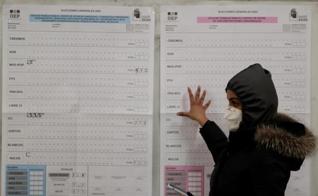 Una mujer consulta las listas de partidos en un colegio electoral de La Paz.