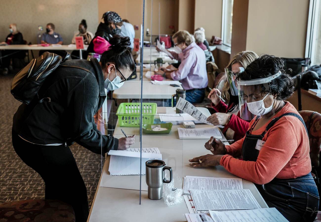 Una votante (L) se registra para recibir su boleto en el Museo de la Guerra Civil en Kenosha, Wisconsin.