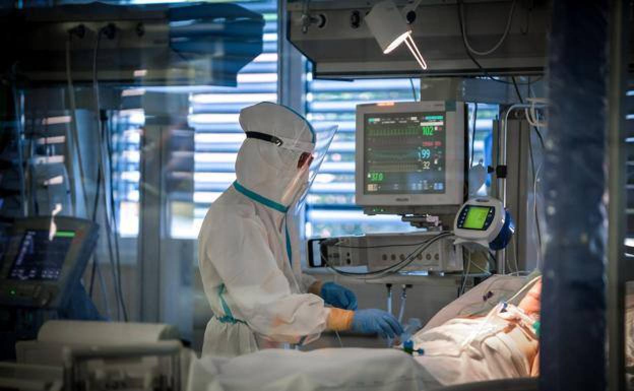Imagen de un sanitario en un hospital, atendiendo a un paciente de Covid-19. 