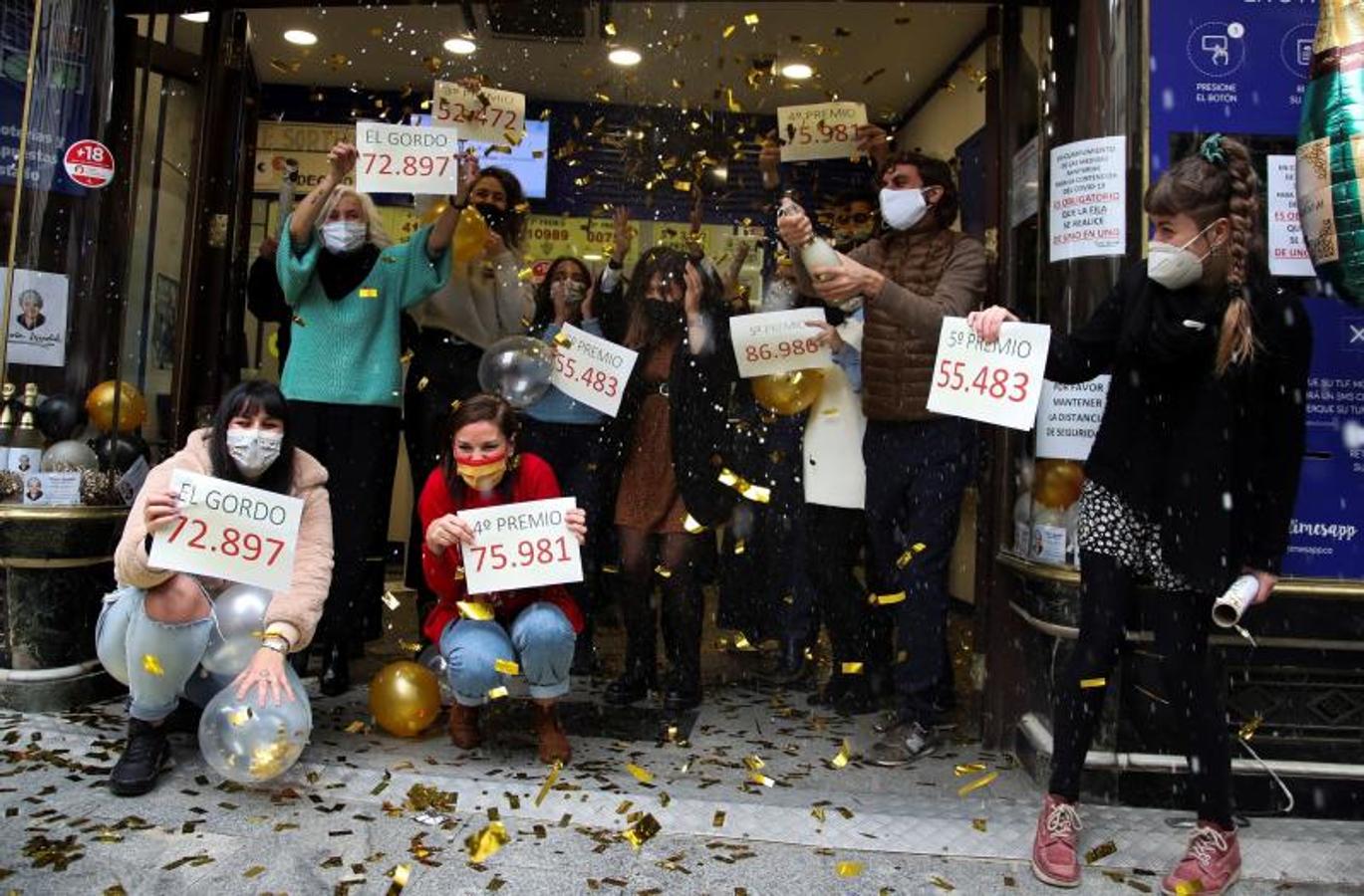 Loteros de la administración de Doña Manolita de Madrid festejan haber vendido décimos del premio gordo.