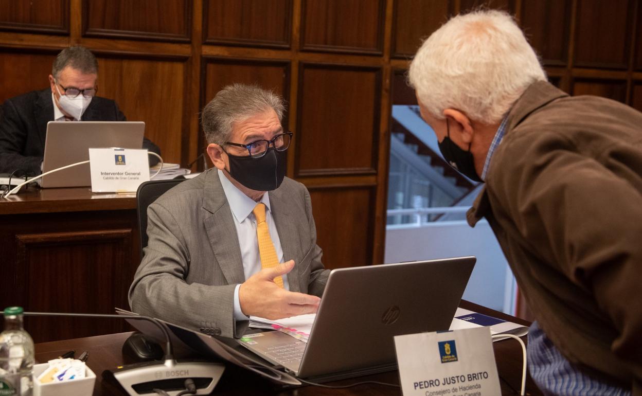 El consejero de Hacienda del Cabildo, Pedro Justo, dialoga con el portavoz de NC, Carmelo Ramírez (derecha), antes del pleno que ayer aprobó inicialmente el presupuesto para 2021. 