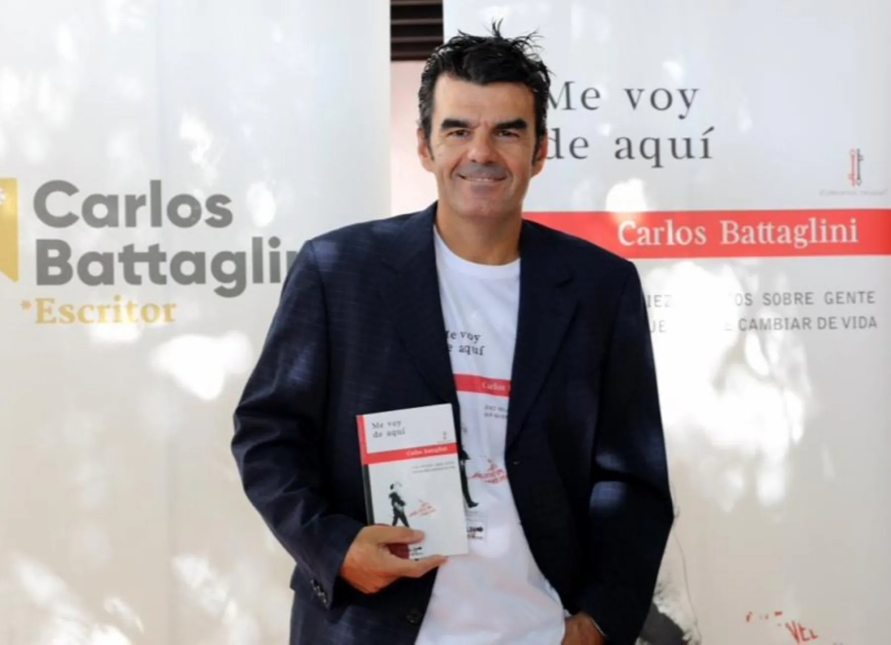 El escritor Carlos Battaglini posa con un ejemplar de su libro 'Me voy de aquí.. 